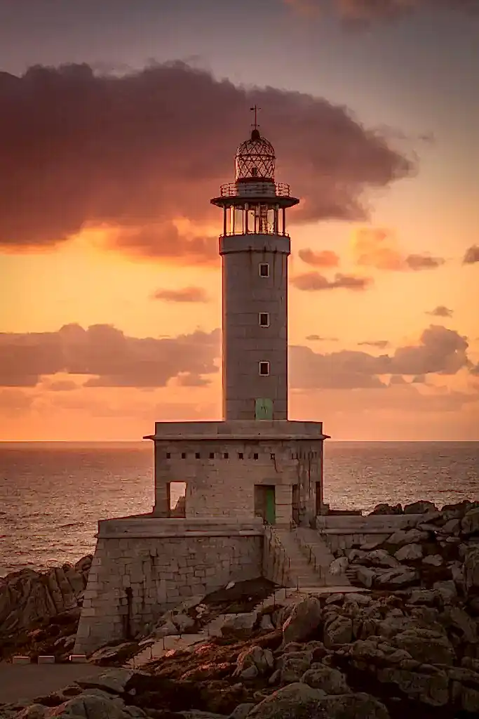 vertical picture punta nariga lighthouse surrounded by sea sunset spain scaled